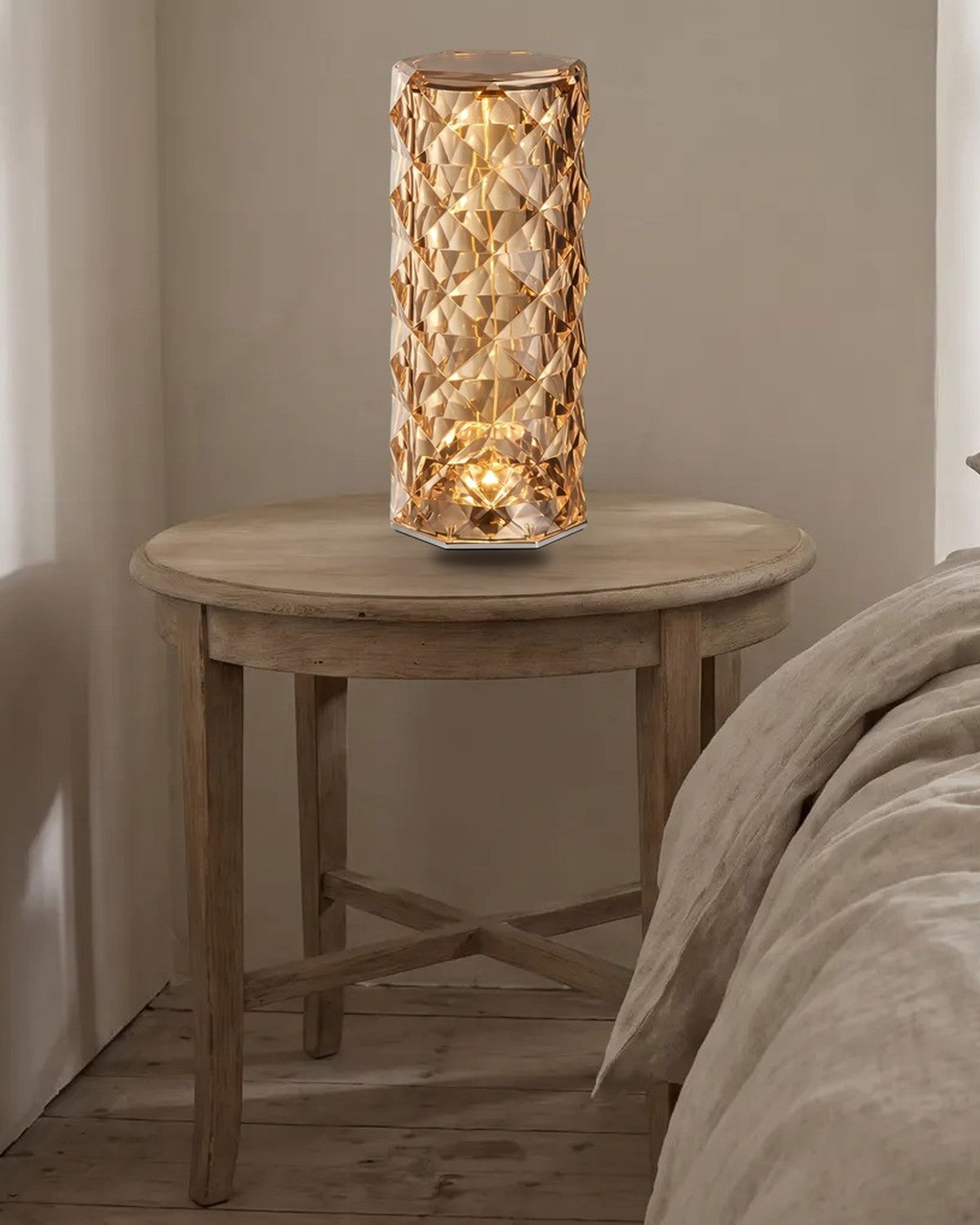 Rose-cut acrylic table lamp glowing warm on a bedside table