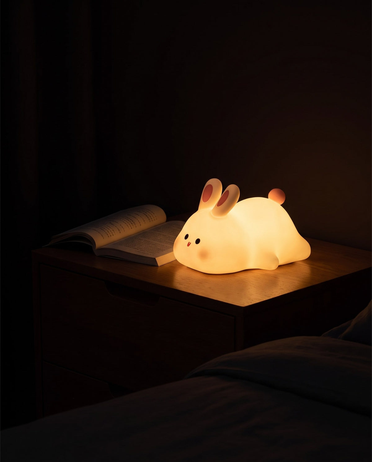 Rabbit-shaped touch lamp glowing softly on a dark bedside table